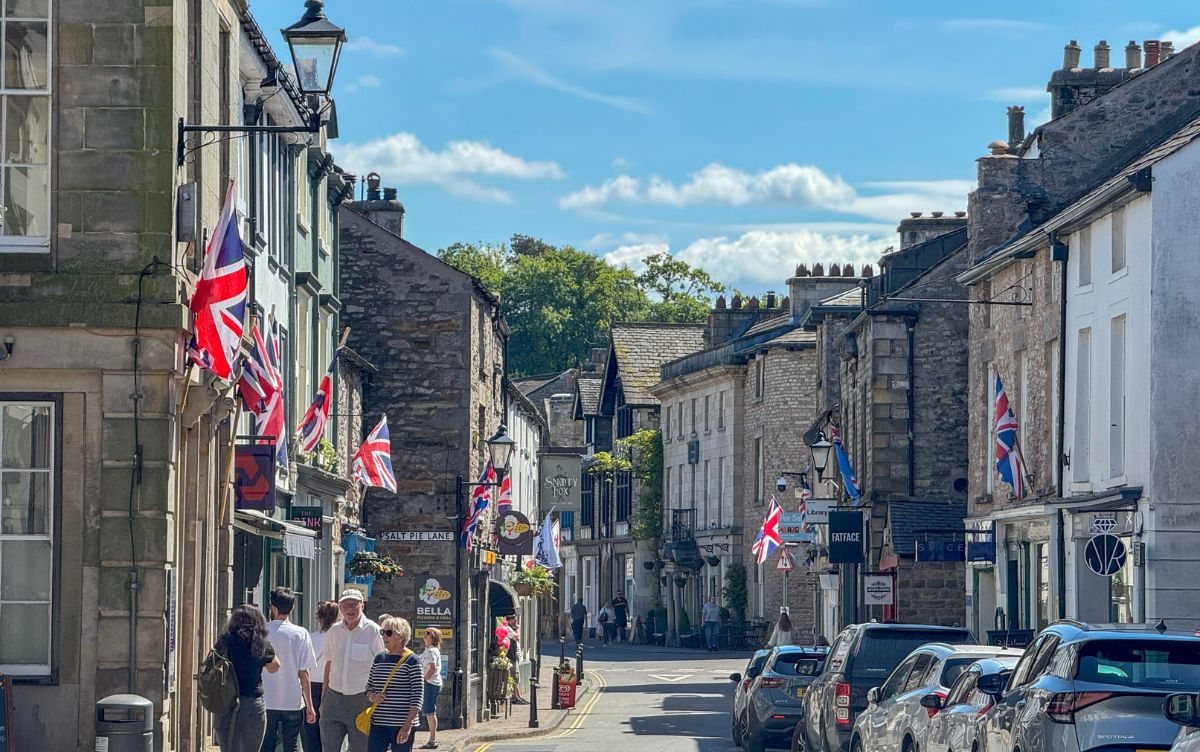 Main street in Kirkby Lonsdale with stone buildings and flags