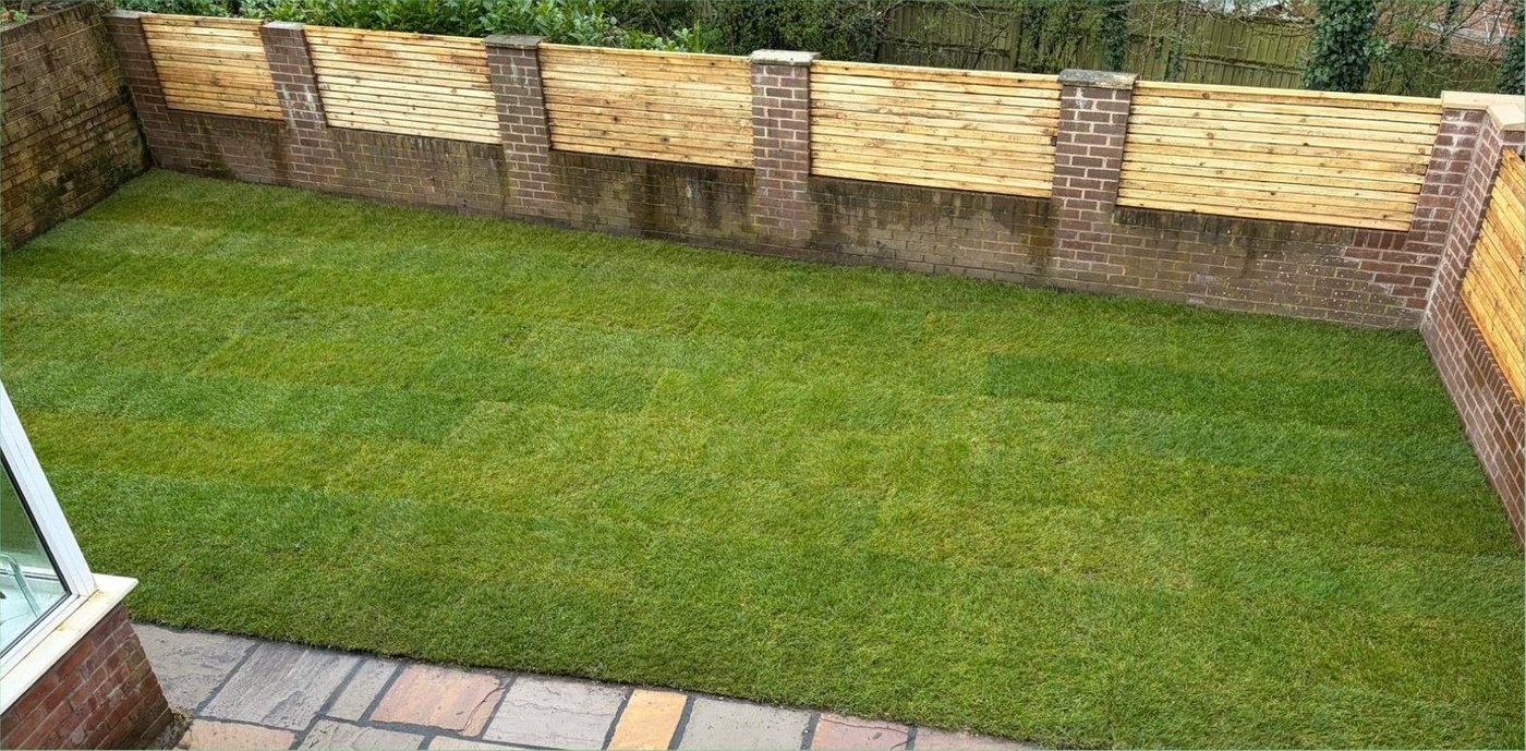 The finished garden with new lawn, rebuilt retaining wall and slatted timber fencing