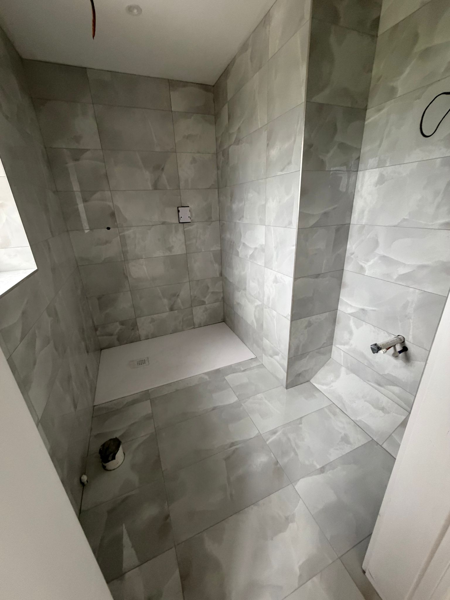 Walk-in wet room with full-height marble effect tiling